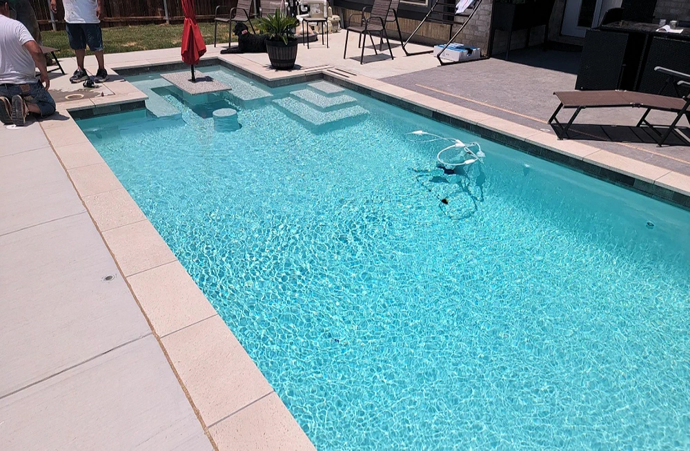 Complete backyard pool with step entry and seating area.